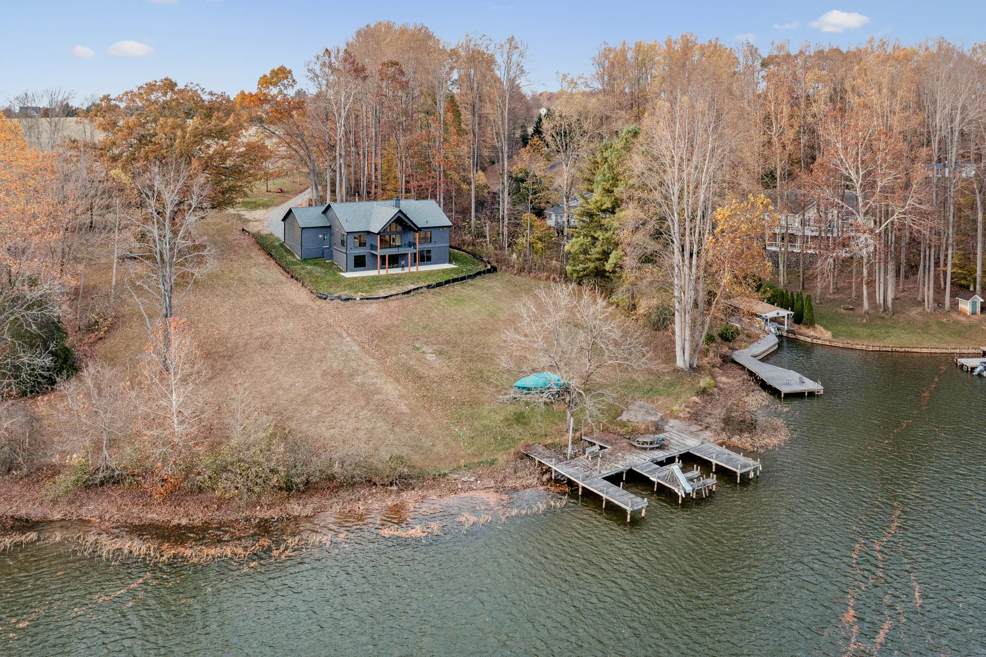 An aerial view of a Spartan Homes custom home on a wooded lot with a private dock and lake shoreline at Lake Anna, Virginia