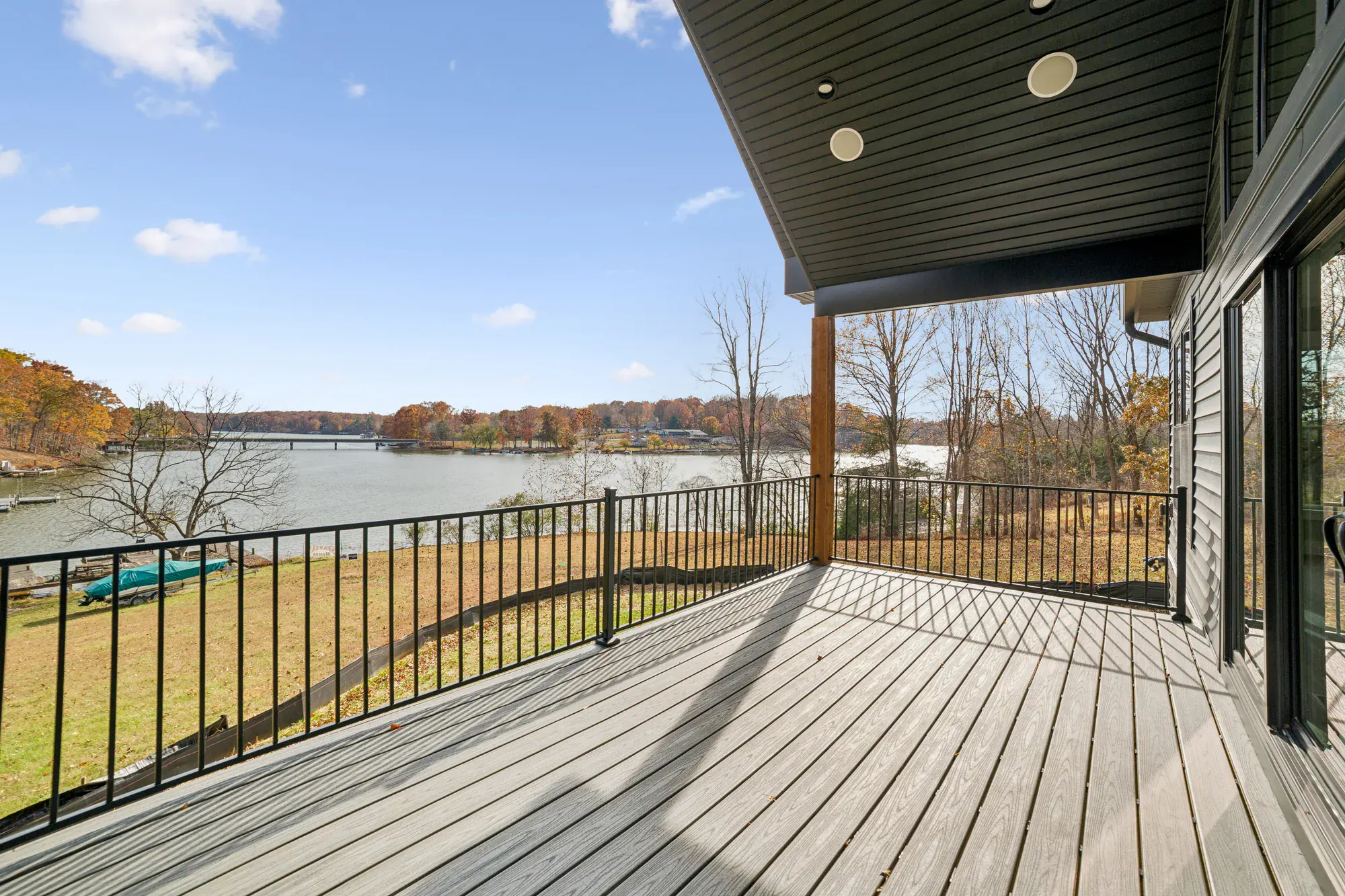 A Spartan Homes covered deck with cable railing and a panoramic lake view at golden hour near Lake Anna, Virginia
