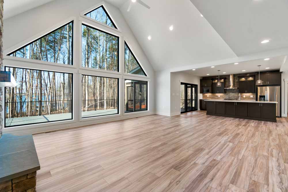 A cathedral window wall over hardwood floors, filling a custom great room with daylight